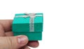 Hand holding small green gift with silver ribbon Royalty Free Stock Photo