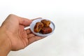 Hand holding a small plate of dates fruit Royalty Free Stock Photo