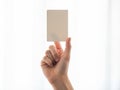 A hand holding a small rectangular object against a plain white background Royalty Free Stock Photo
