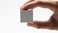 Hand holding small square object against white background Royalty Free Stock Photo