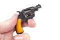 Hand holding small tiny toy gun prop pulling the trigger isolated on white background Royalty Free Stock Photo