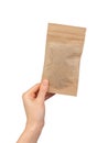 Hand holding small zip-lock kraft paper bag. Ziplock pouch, eco brown beige package