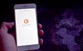 Hand holding smarphone with DuckDuckGo search engine displayed