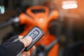 Hand holding Smart Key or remote control with motorcycle background. Remote Control key Protect and safe vehicle from Theft  . Royalty Free Stock Photo
