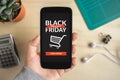 Hand holding smart phone with Black Friday concept on screen Royalty Free Stock Photo