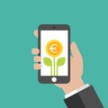 Hand holding smart phone with green leaves and euro coin as a flower on the screen Royalty Free Stock Photo
