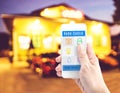 Hand holding smart phone with home control application with blur Royalty Free Stock Photo