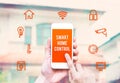 Hand holding smart phone with home control application with blur Royalty Free Stock Photo