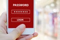 Hand holding smart phone with password login on screen over blur background, cyber security Royalty Free Stock Photo