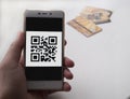 Hand holding smart phone with QR code. 3 bank cards on background Royalty Free Stock Photo