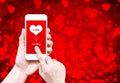 Hand holding smart phone with sending love word and heart shape