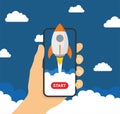 Hand holding smartphon with launch rocket on the screen - stock vector