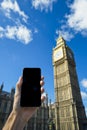 Hand Holding Smartphone at Big Ben Westminster Palace London