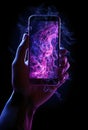 Hand holding a smartphone with blue and pink smoke on a black background Royalty Free Stock Photo