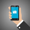 Hand holding smartphone with camera icon Royalty Free Stock Photo