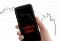 Hand holding a smartphone with the message margin call