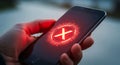 Hand Holding Smartphone with Red Error X Symbol on Screen Royalty Free Stock Photo