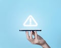 Hand-holding smartphone showing warning triangle and exclamation mark icon Warning about a dangerous problem Server error. Royalty Free Stock Photo
