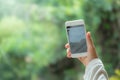 Hand holding a smartphone taking photos of forest and nature on mobile screen in camera mode in blurred natural background Royalty Free Stock Photo
