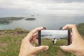 Hand holding Smartphone taking picture of nature landscape view. Royalty Free Stock Photo