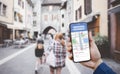 Hand holding Smartphone with Tourists using GPS map navigation apps on smartphone, blurred road background close up concept of onl