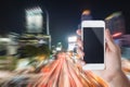 Hand holding smartphone with traffic jam in the city