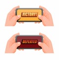 Hand holding smartphone with victory and defeated pop up icon set, mobile gaming esport symbol in cartoon illustration vector