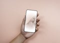 Hand holding smartphone with a white blank screen with black frame. Royalty Free Stock Photo