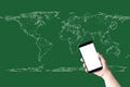 Hand holding smartphone and white screen on world map and green background. Business, technology, learning, and travel concept Royalty Free Stock Photo