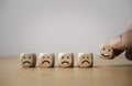 Hand holding smile face which print screen on wooden cube block among sad face for positive thinking mindset concept Royalty Free Stock Photo