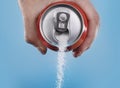 Hand holding soda can pouring a crazy amount of sugar in metaphor of sugar content of a refresh drink Royalty Free Stock Photo