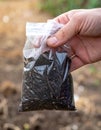Hand holding soil sample in a plastic bag. Concept for gardening, agriculture, environmental science, forensic analysis. Royalty Free Stock Photo