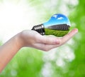 Hand holding solar panels in light bulb Royalty Free Stock Photo