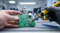 Hand is skillfully using a soldering iron to repair an electronic circuit board in a workshop Royalty Free Stock Photo