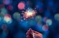 hand holding sparkler light burning on bokeh background