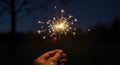 Hand holding sparkler at nighttime celebration Royalty Free Stock Photo