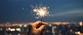 Hand Holding Sparkler Over Night Cityscape, Celebration of Lights