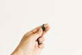 Hand holding spirulina capsule on white wall background. Morning vitamin nutrient pill. Dietary supplements. Health support and