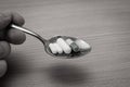 Hand holding a spoon of drugs. Eating antidepressants concept