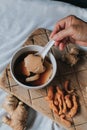 Hand holding spoon eating homemade soy custard in hot ginger syrup eat with with deep fried powder pastry good for health