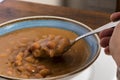 Hand holding spoon full of traditional Colombian soup beans Royalty Free Stock Photo