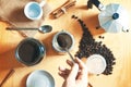 Hand holding a spoon preparing some expresso cafe with a coffee pot on a rustic wooden table. Next, some ground coffee and beans Royalty Free Stock Photo