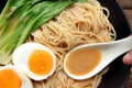 Hand holding spoon, ramen soup inside the spoon.Delicious miso ramen soup with egg in a bowl. Royalty Free Stock Photo