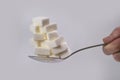 Hand holding spoon with stack of sugar cubes piled unhealthy nutrition, diet and sugar addiction concept Royalty Free Stock Photo