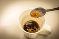 Hand holding a spoon to scoop coffee into a glass Royalty Free Stock Photo