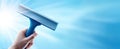 The hand holding a squeegee against a bright blue background. AI generated image Royalty Free Stock Photo