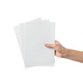 A hand holding a stack of blank white paper sheets against a white background Royalty Free Stock Photo