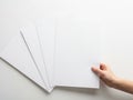 A hand holding a stack of blank white paper sheets against a white background isolated on white background Royalty Free Stock Photo