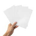 A hand holding a stack of blank white paper sheets against a plain background Royalty Free Stock Photo