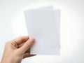 A hand holding a stack of blank white paper sheets against a plain background Royalty Free Stock Photo